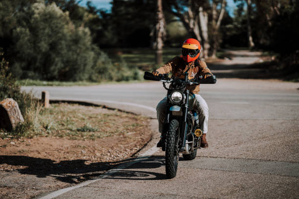istock a person riding on a motorcycle down the road under a tree 2138423366