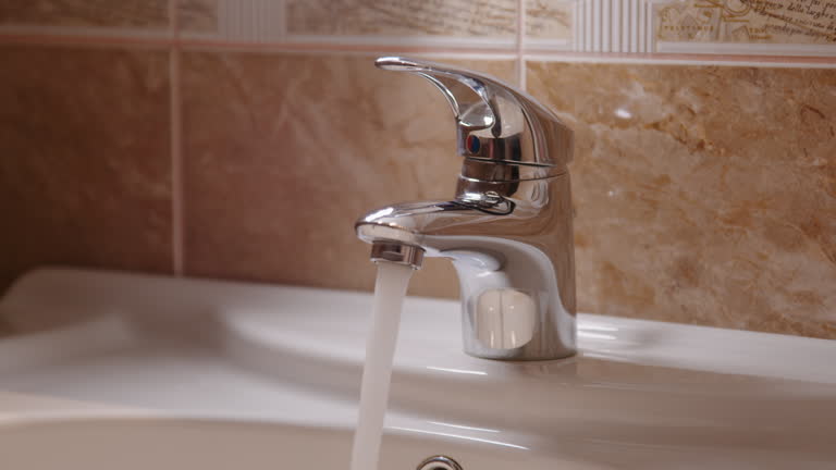 Close-up on sink and faucet water trickles down. Sink and faucet significance of maintaining skin hygiene and clean surfaces to uphold healthy lifestyle minimize risk of illnesses sink and faucet.