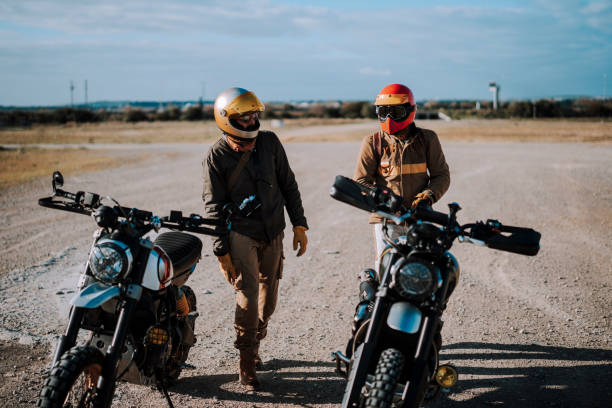 istock two men wearing helmets standing beside a parked motorcycle in a desert 2138451402