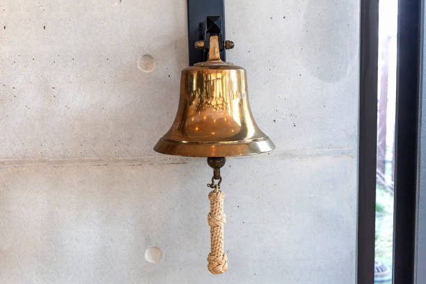 istock Brass bell on a gray wall indoors. 2138458820