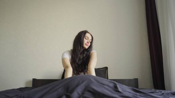 Well-rested woman enjoying happy morning in bed,