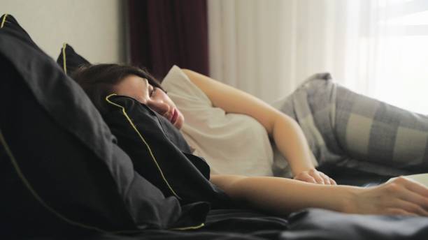 istock Young female lying on the bed neat to her laptop while sleeping 2138480176