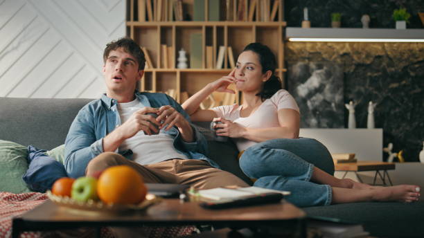 istock Married couple relaxing couch with coffee cozy weekend evening. Spouses talking 2138514440