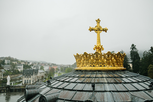 A golden Christian Cross on top of a dome
