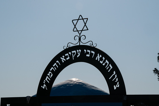 Star of David Jewish symbol on top of shul dome against blue sky