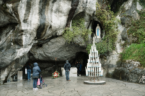 Lourdes, France - 26 March, 2024: Massabielle grotto an Virgin Mary statue in Lourdes, France