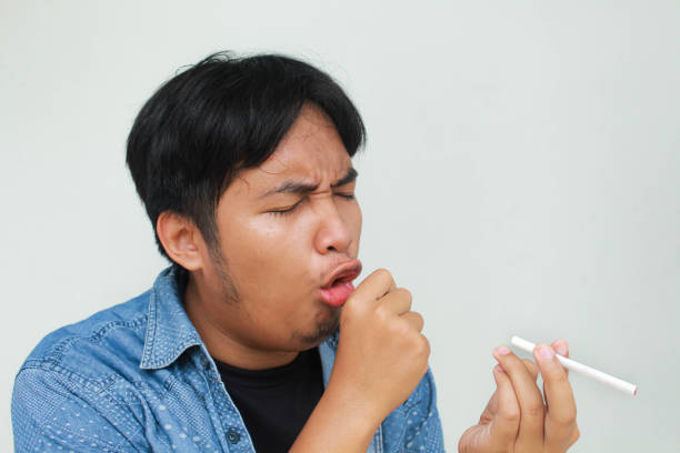 istock Smoker holding a cigarette suffering from chronic cough, Asian man patient coughing with respiratory problems 2138656592