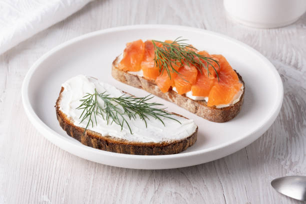 istock Rye sandwich with salmon and cream cheese on white wooden table 2138662903