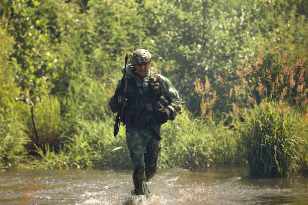 Special forces soldier with weapon take part in military maneuver. War, army, technology and people concept.