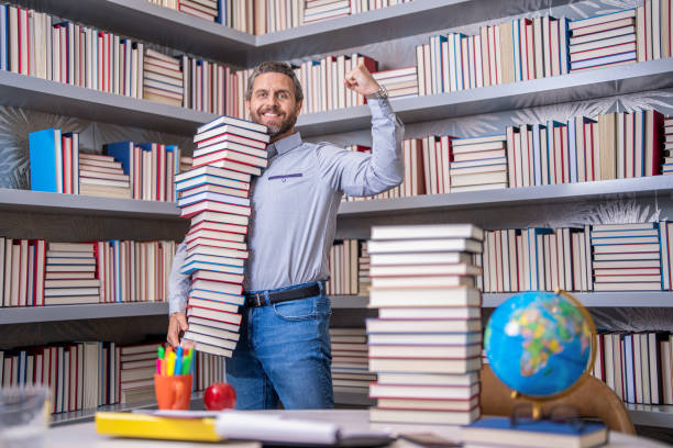 istock school library. Teachers day. Teacher in school classroom. teacher with book in library classroom. Hispanic teacher in college. Man with books in library. Knowledge and education. Quality education 2138701072