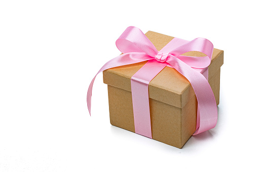 Brown gift box with pink ribbon isolated on white background. High angle view. High resolution 42Mp studio digital capture taken with Sony A7rII and Sony FE 90mm f2.8 macro G OSS lens