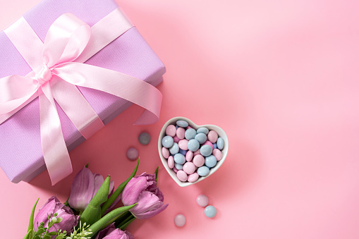Mother's Day design concept background with tulips, candies and gift on pink background. High resolution 42Mp studio digital capture taken with Sony A7rII and Sony FE 90mm f2.8 macro G OSS lens