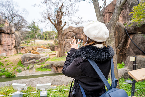 Woman taking photo in the zoo with happy in Osaka, Japan.