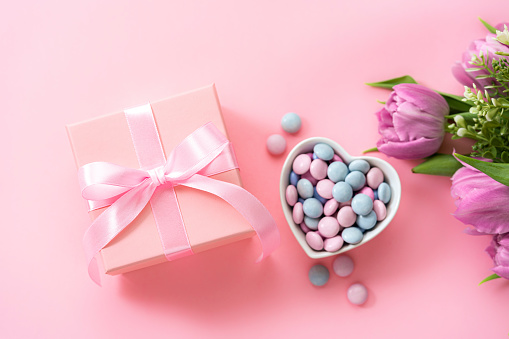 Mother's Day design concept background with tulips, candies and gift on pink background. High resolution 42Mp studio digital capture taken with Sony A7rII and Sony FE 90mm f2.8 macro G OSS lens