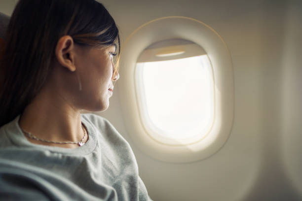 istock Woman sit on air plane seat looking out window 2138703698