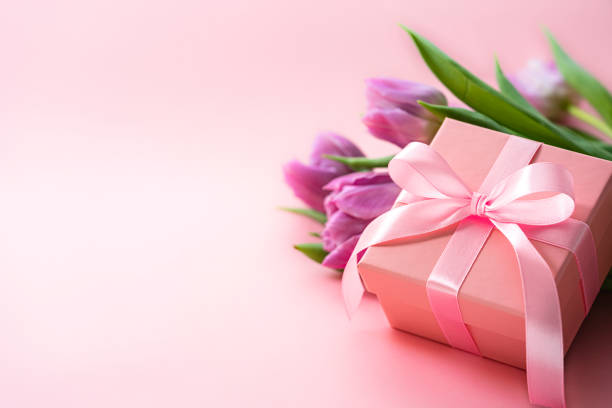 istock Mother's Day concept with tulips and gift box on pink background. Copy space 2138703712