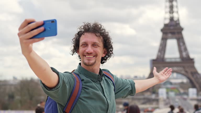 Adult Male Tourist Having Video Call With The View Of Eiffel Tower In Paris, France