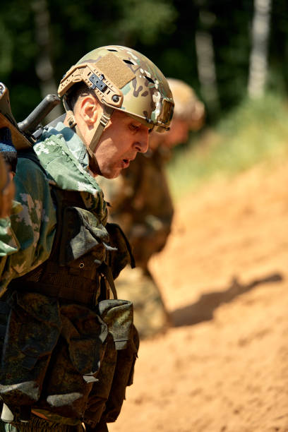 istock Full military experience - One day commando - running through the water with automatic rifle replica 2138737870