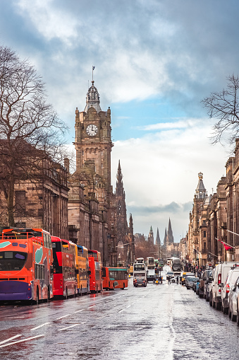 Tourist buses parked along Princes Street in Edinburgh, Scotland, with the Balmoral Hotel clock tower visible