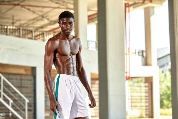 Handsome African American sportman standing on the street while taking break after training. Black male having rest after workout.