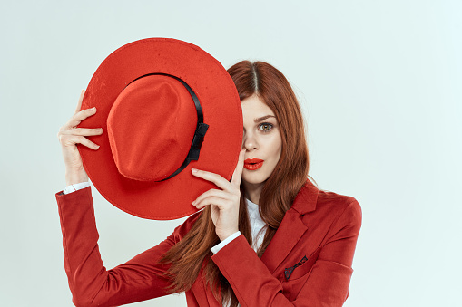 beautiful woman in red hat blazer makeup elegant style light background studio. High quality photo