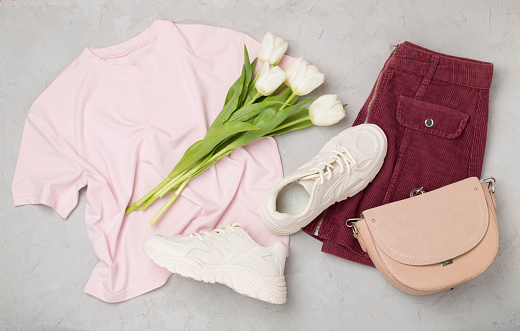 Flat lay with trendy spring outfit on concrete background, top view