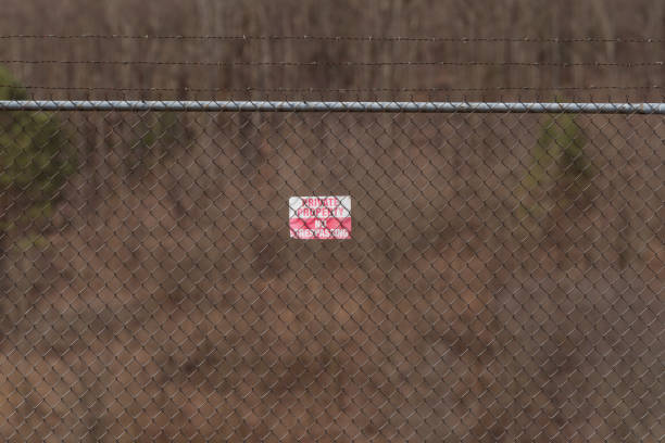 man,day,fence,gate,private property sign,no trespassing sign,horizontal,posted property