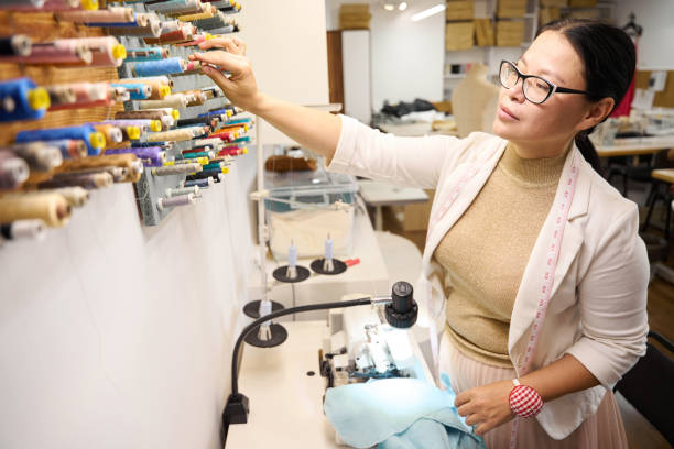 istock Dressmaker selects a spool of thread at a special stand 2138768436