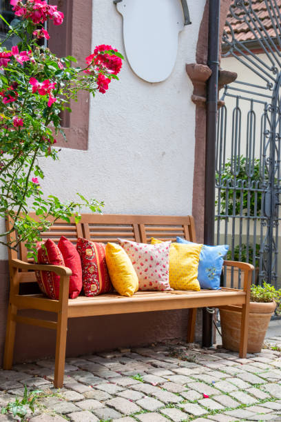 istock Wood bench outside with much multicolor pillows. 2138786594