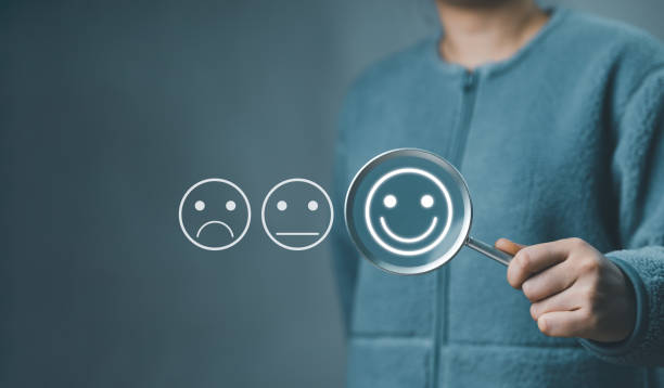 istock Customer review satisfaction feedback survey concept. Hand holding a magnifying glass with positive thinking emoticons among neutral and negative ones, Smiling face, mental health, business evaluation 2138814620