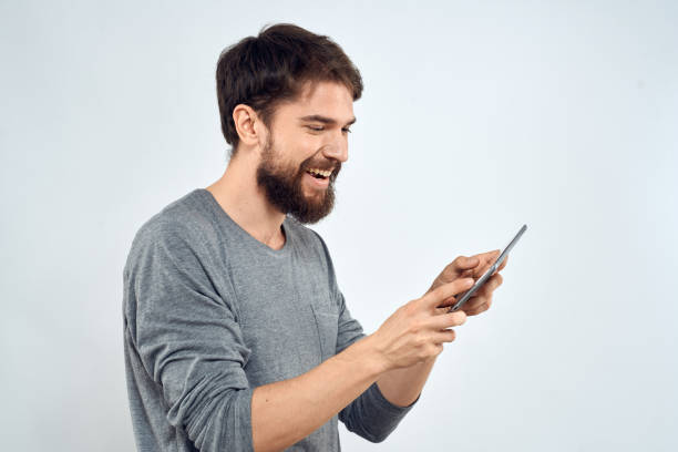 istock A man with a tablet in his hand internet technology communication gray jacket light background 2138840392