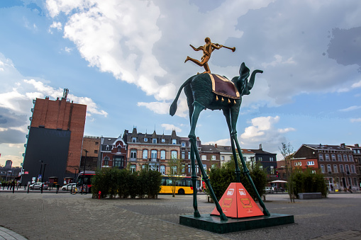 04-19-2016  Liege  BELGIUM  Statue of Salvador Dali As advertising of his exhibition  (elephant and boy with a pipe on his back
)  Liege. People and bus  on far distance.