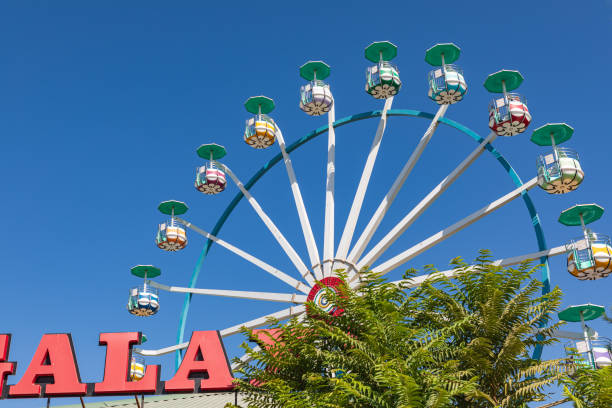 Retro toned close up picture of two Ferris wheel cars with cloudless sky, space for text.