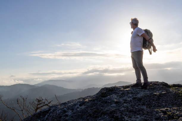 istock Mature hiker arrives on mountain top at sunset 2138864412