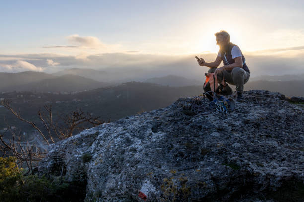 istock Mature hiker uses mobile phone on mountain top 2138867508