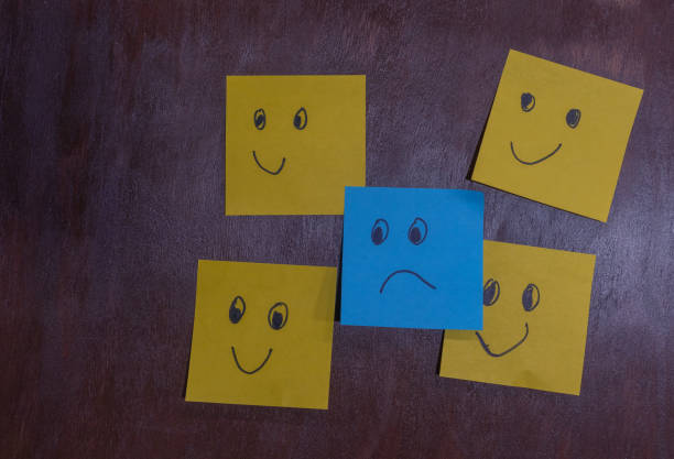 istock Flat lay of yellow sticky notes with happy faces, one blue note with sad face 2138867576