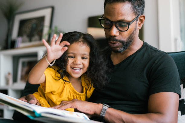 istock Affectionate father reading book with adorable mixed race daughter 2138868194