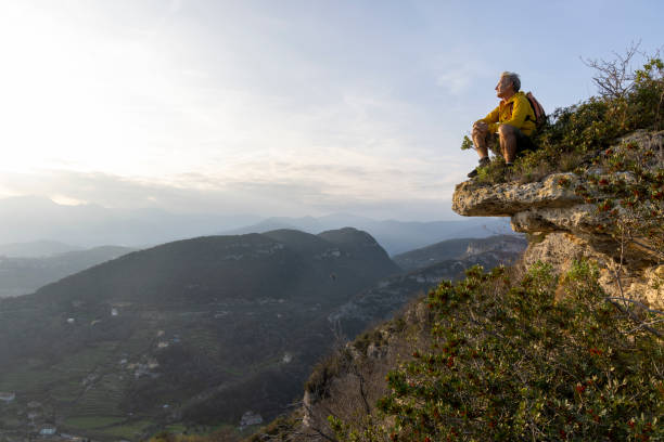istock Mature hiker sits on cliff edge and looks out 2138868200