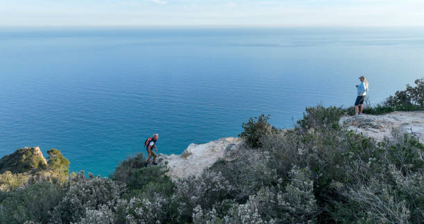 istock Mature couple ascend rock ridge crest 2138868661