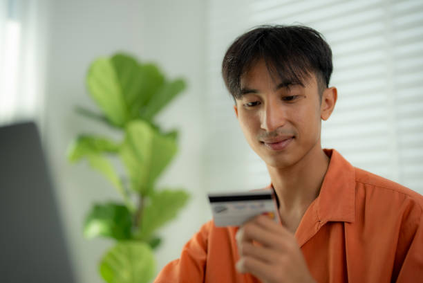 istock Asian man using a laptop and credit card. 2138892950