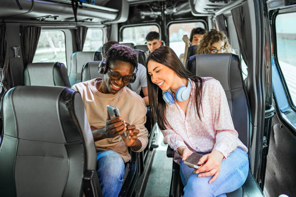 istock Friends looking at a mobile phone while sitting on the bus 2138893335