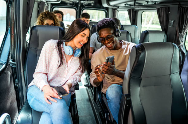 istock Friends looking at a mobile phone while sitting on the bus 2138893469