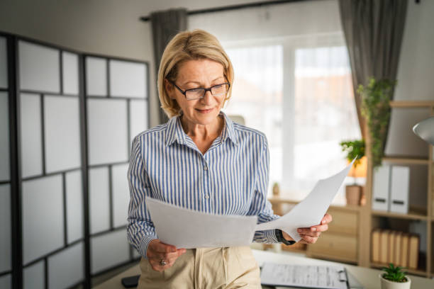 mature woman read contract document paper at office happy smile