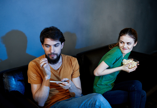 emotional man and woman watching tv indoors. High quality photo