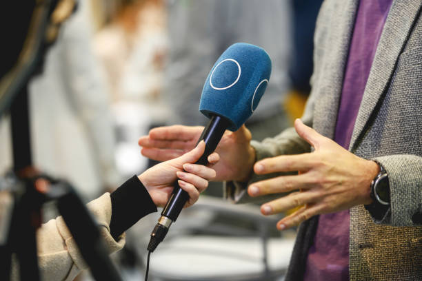 Politician gesturing while giving an interview and explaining the idea of the project to a journalist at a press conference