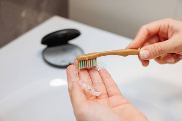 Woman's hand holding invisible aligners.