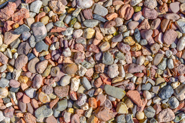 Background of different stones, round crushed stone, rocks. Multicolored round stone gravel crumbs background