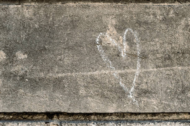 istock Heart shape drawn with white chalk on a rough rock surface 2138942854