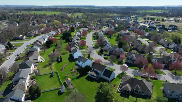 Small town in America at sunny day in spring. Homes in quiet quaint residential housing district of USA. Aerial drone establishing shot.