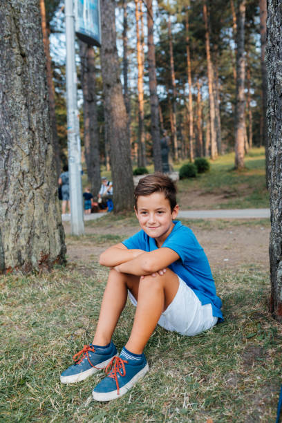 Handsome teenage boy standing in the forest